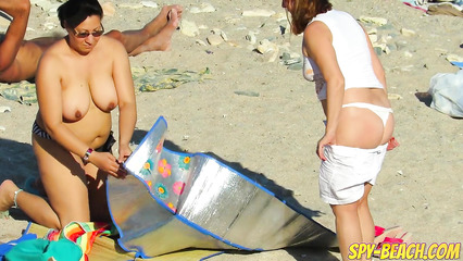 Зрелые бабы не стесняются загорать обнаженными на общественном пляже
